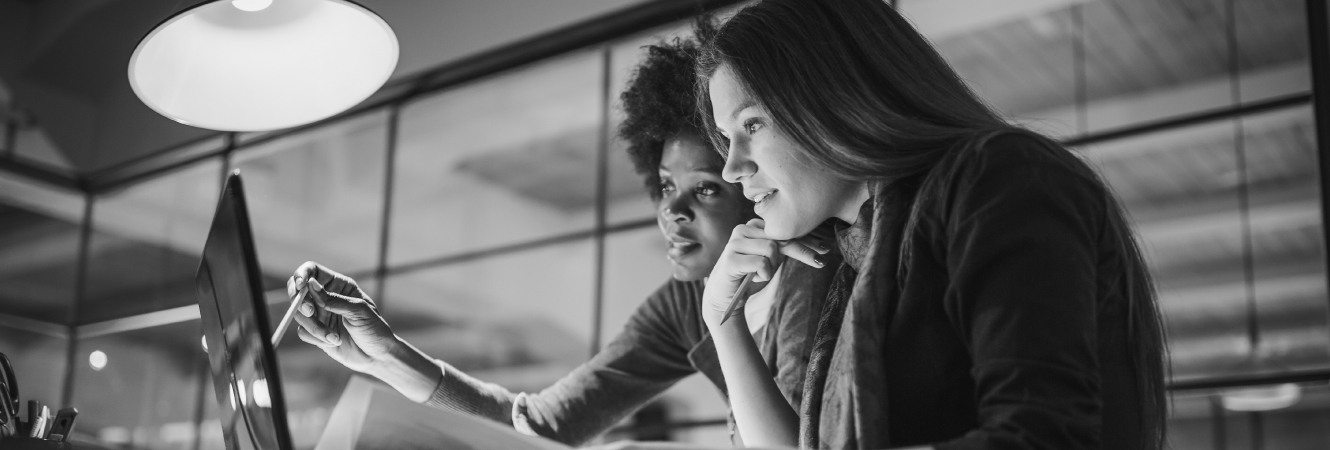 Female coworkers looking at computer