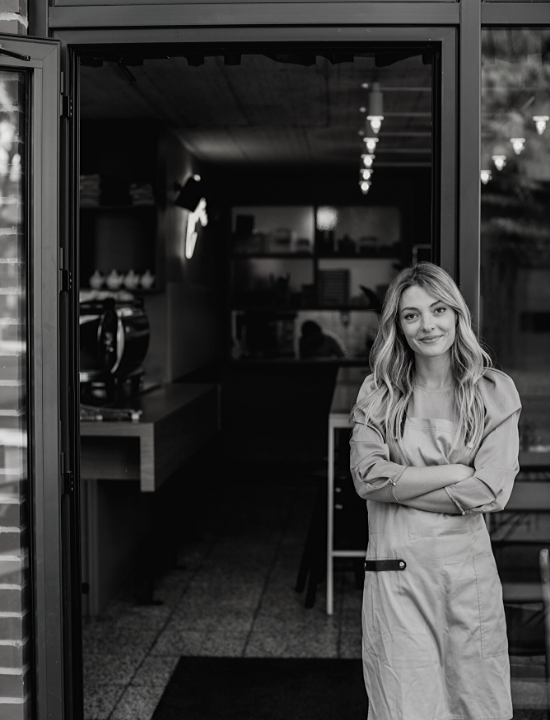 woman smirking at the entrance to her local business