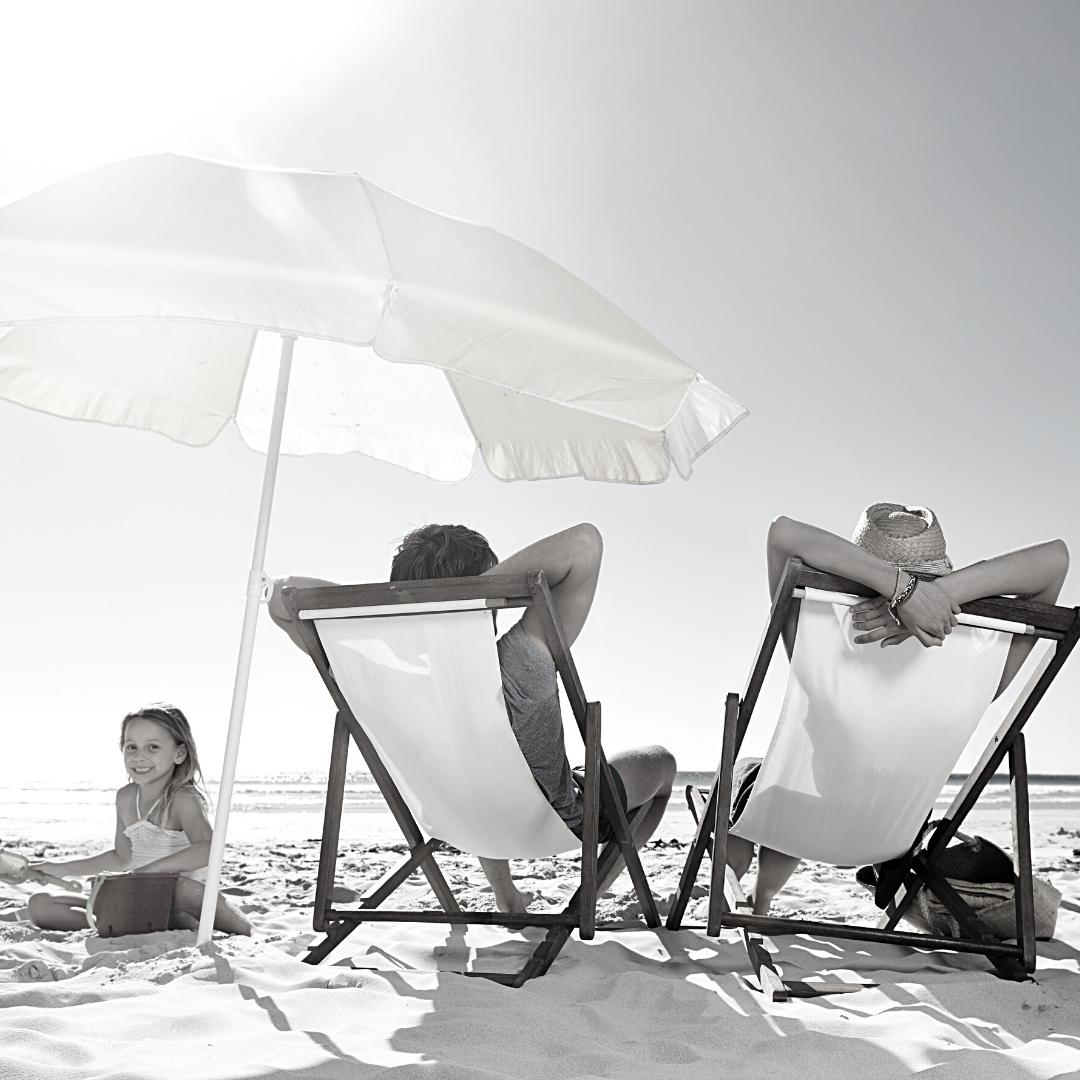 adults and child on the beach vacationing