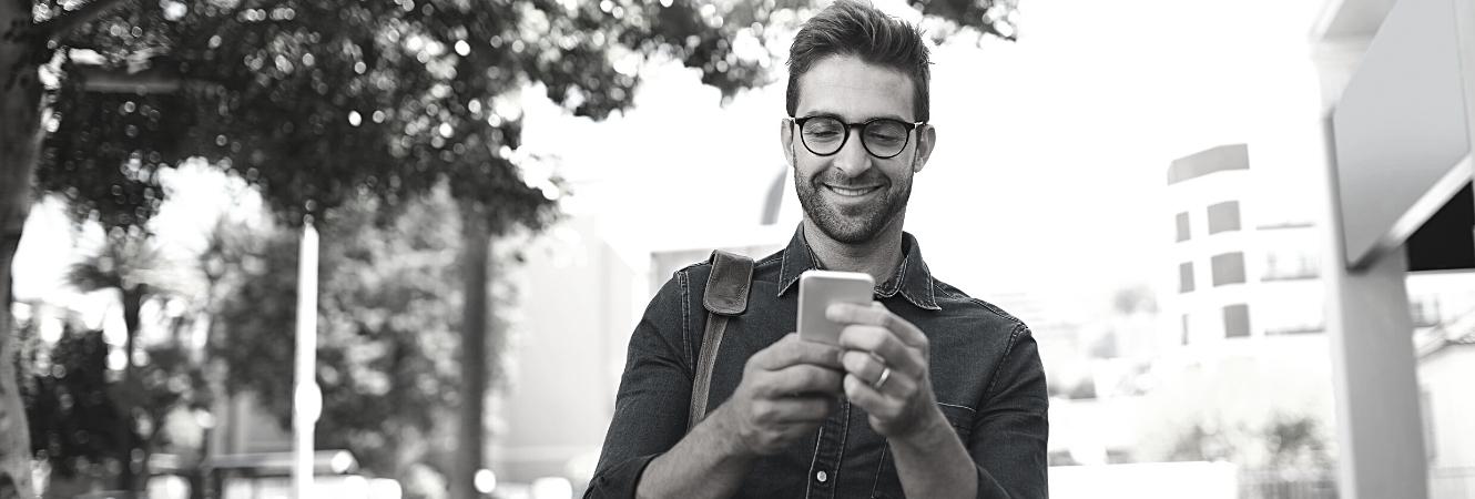 young guy with glasses looking at cell phone