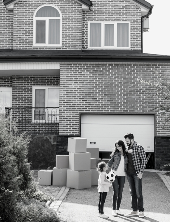 Family in front of home with moving boxes