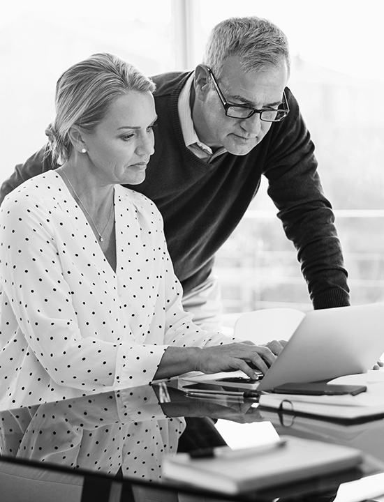 Older white couple looking at laptop.