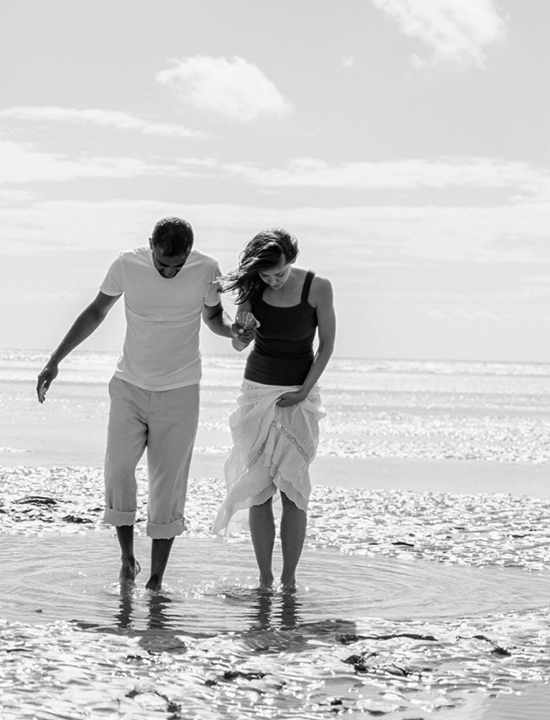 Couple holding hands and walking on the beach