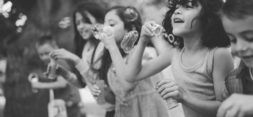 group of kids blowing bubbles outdoors