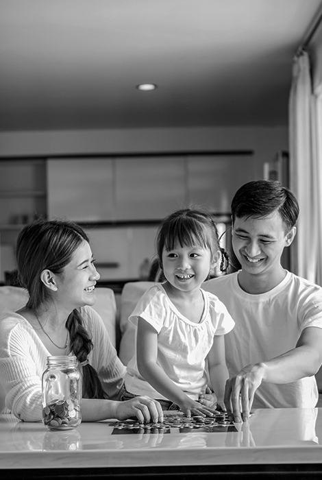 Asian family at home with child counting coins.