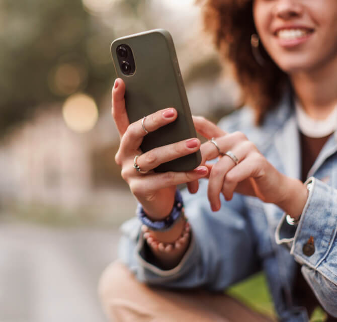 happy woman using phone outside