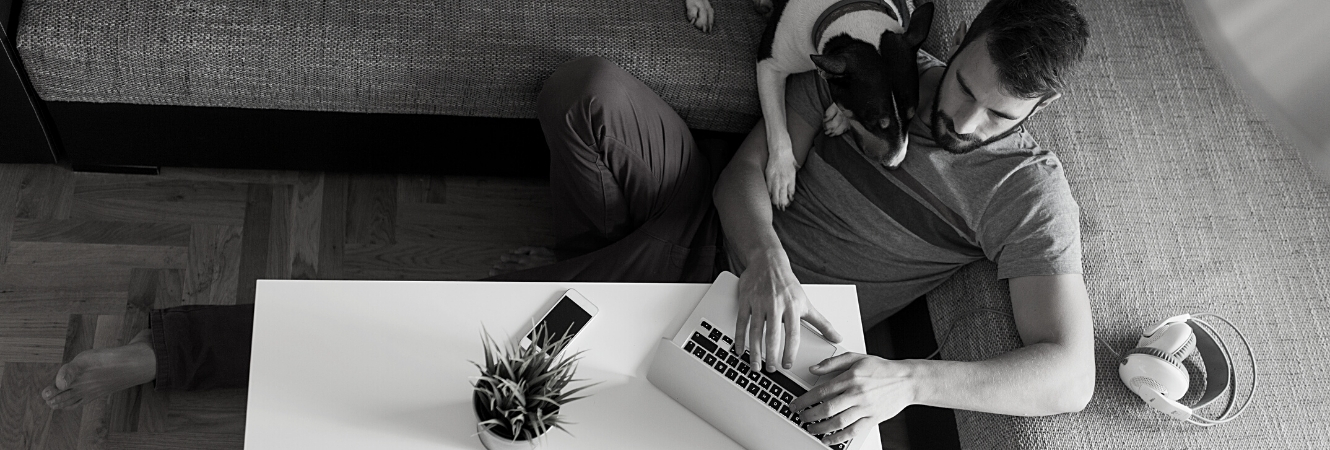 man with his dog browsing the internet on his laptop