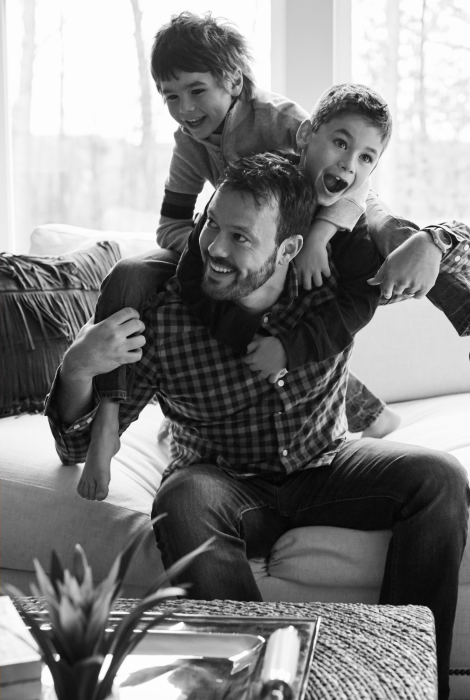 Two boys jumping on their dad's back
