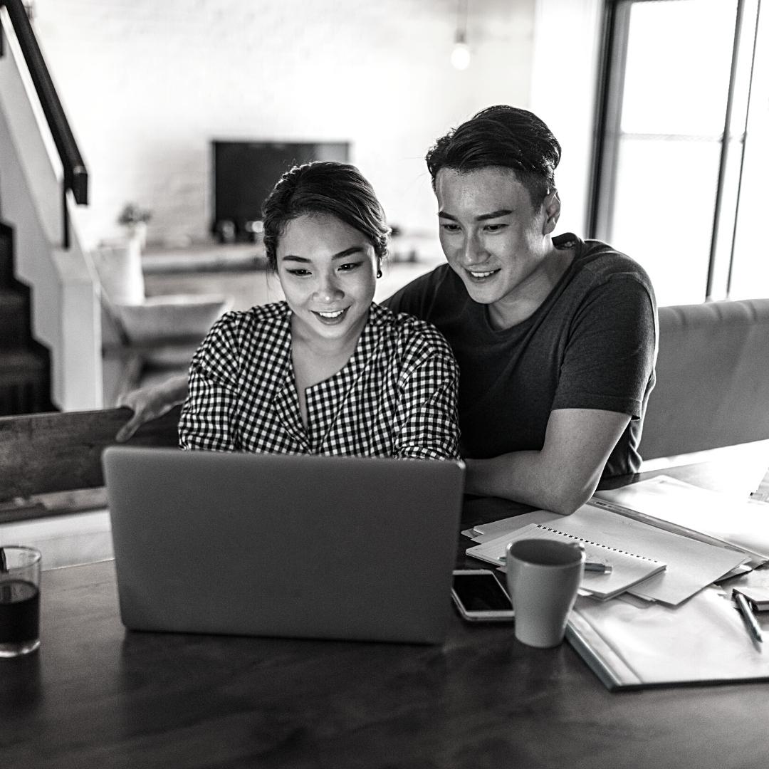 Asian couple looking at laptop